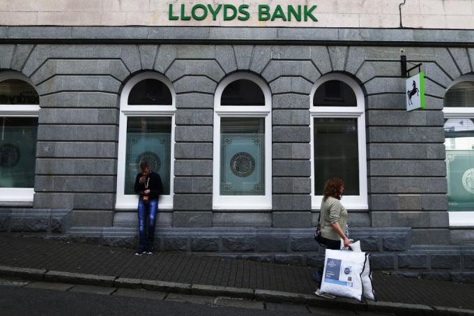 Женщина идет за великобританским банком, банком Lloyds, на острове Гернси